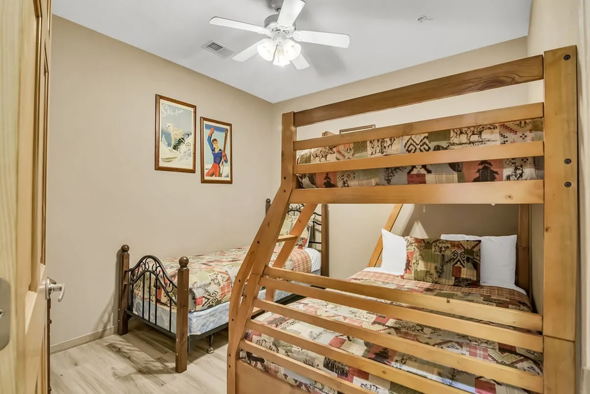 This interior image features a playful bunk bed with patterned bedding and decorative wall art, establishing a fun and cozy atmosphere for kids. The room is clearly designed for group downtime and playful mornings, reflecting the family-friendly amenities described.